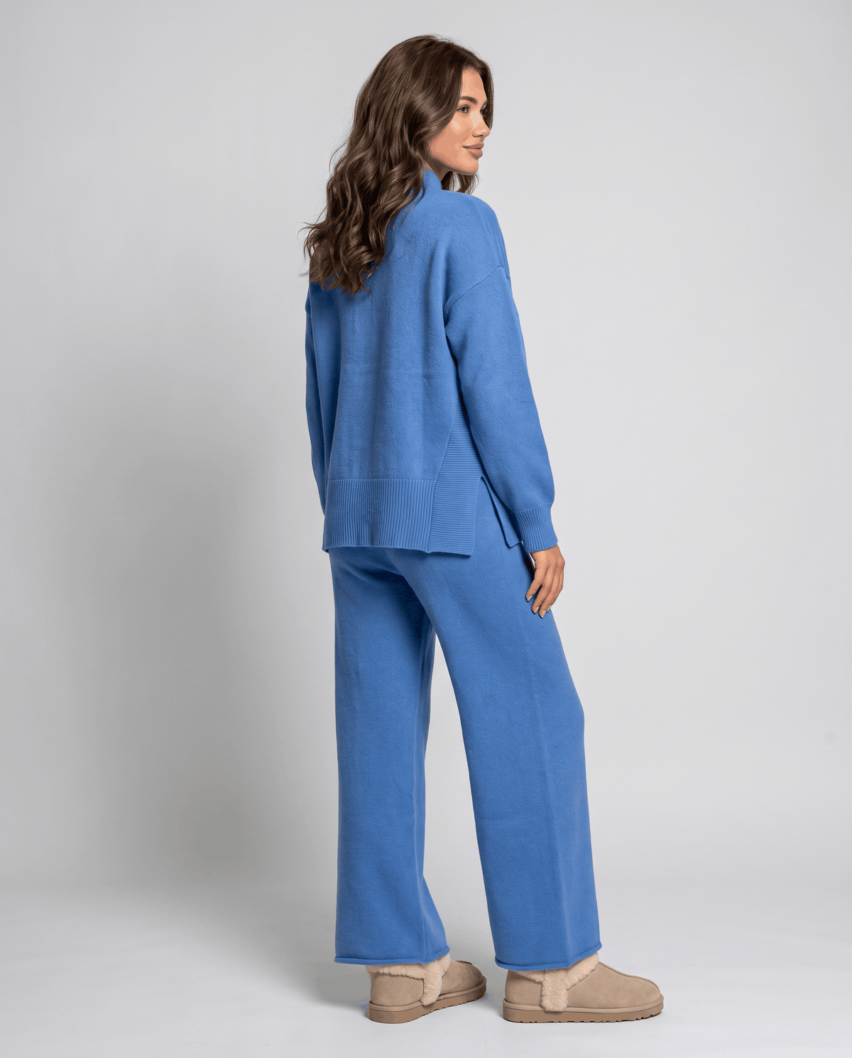 Back view of the blue cable knit pullover and wide-leg pants