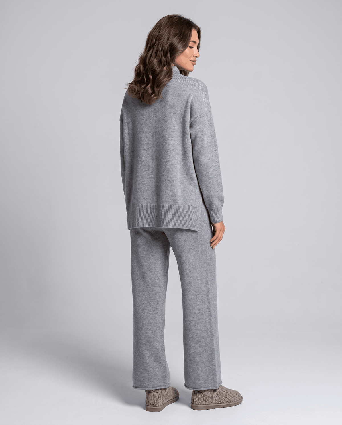 Back view of the grey cable knit pullover and wide-leg pants