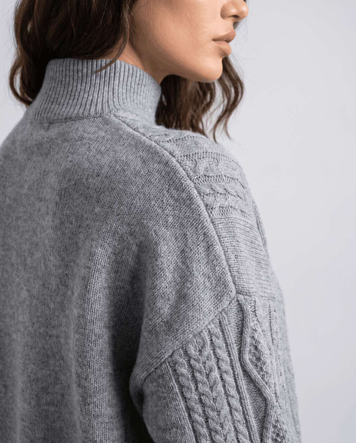 Close-up of the grey cable pattern on the sleeve and mock neckline