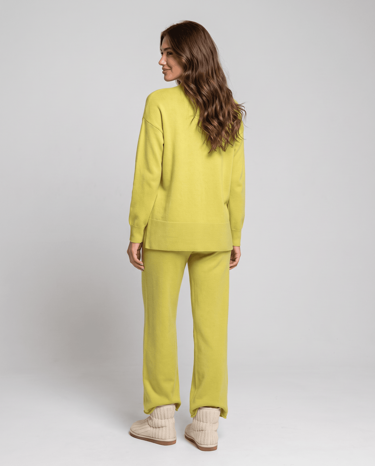 Back view of the lime green cable knit pullover and wide-leg pants