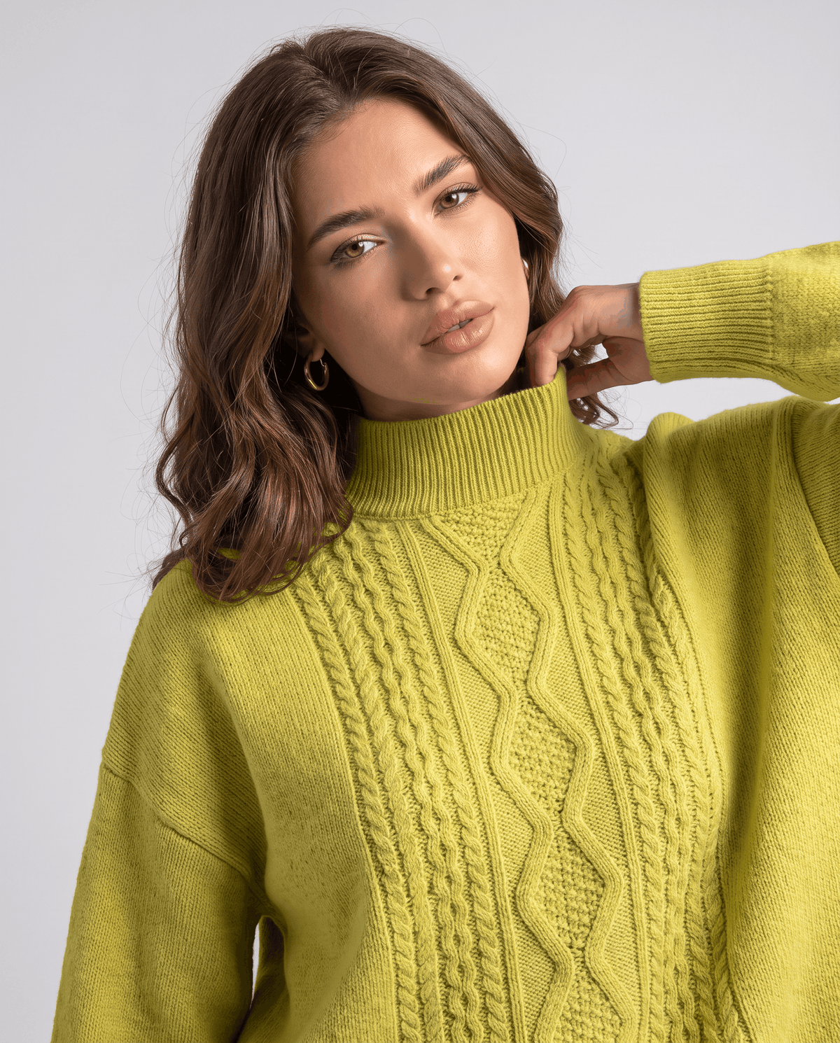 Close-up of the lime green cable pattern and mock neckline