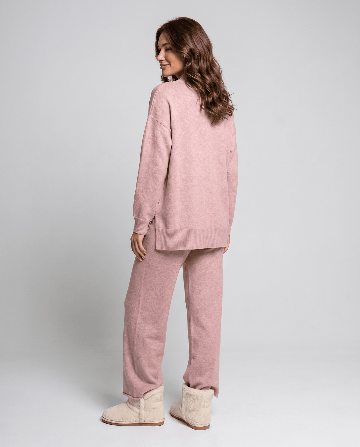 Back view of the pink cable knit pullover and wide-leg pants