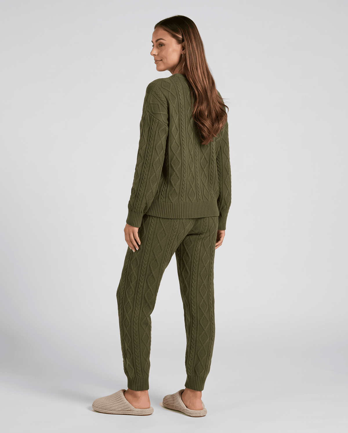 Back view of woman in army green cable knit sweater and joggers
