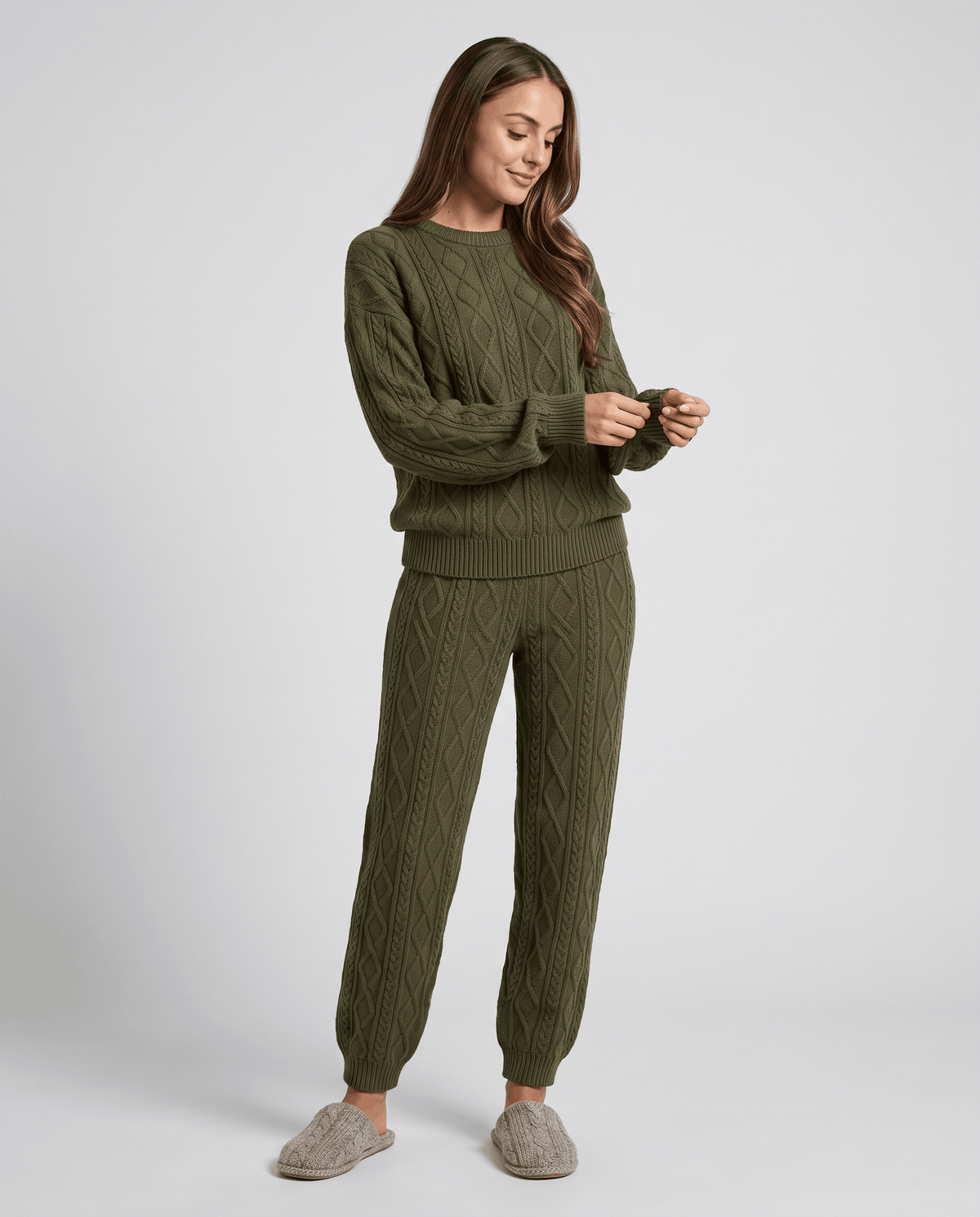 Woman wearing an army green cable knit sweater and matching jogger pants