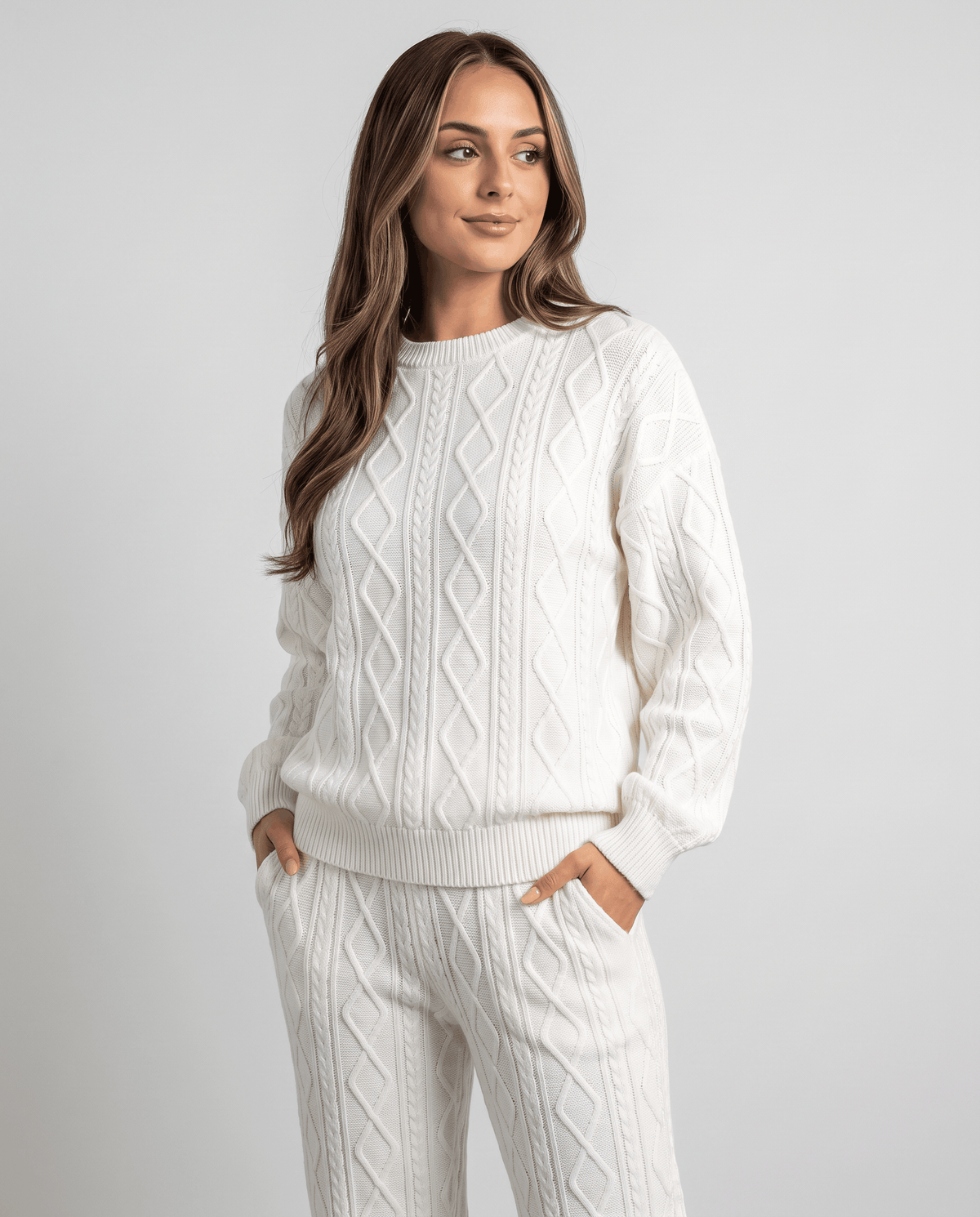 Close-up of cream cable knit crew neck sweater with long sleeves