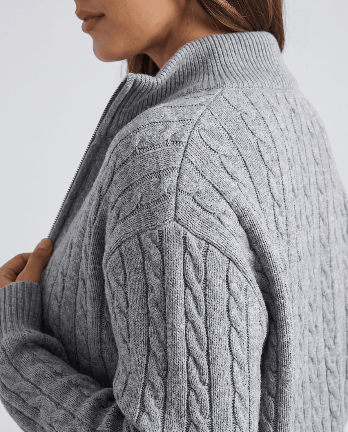 Side close-up of the collar and cable texture on the gray knit jacket