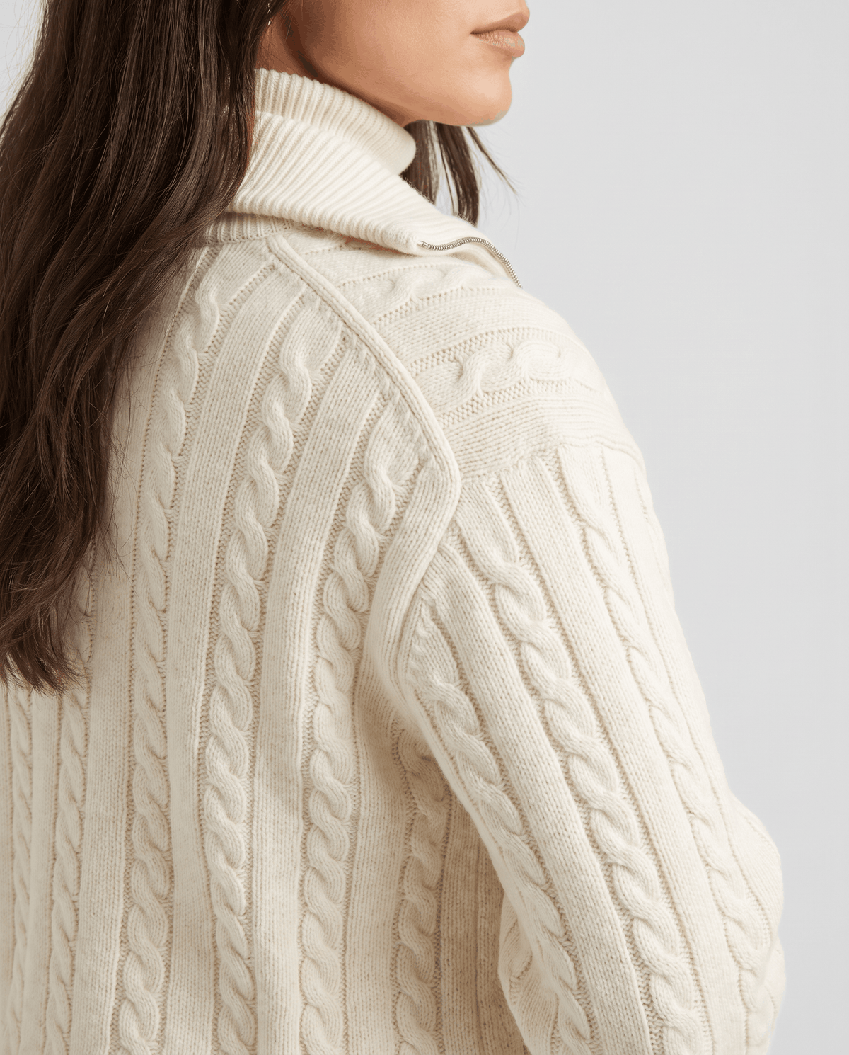 Close-up of the cable-knit texture and folded collar on the off-white jacket