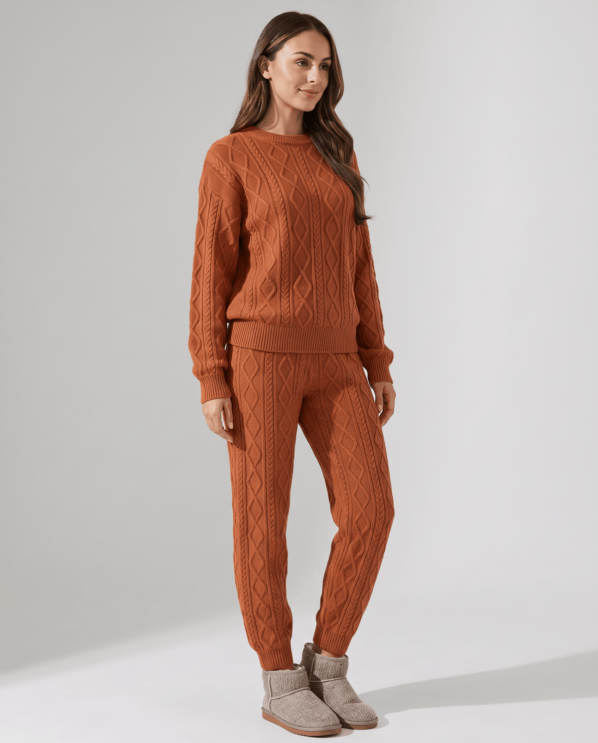 Back view of woman in orange cable knit sweater and jogger pants