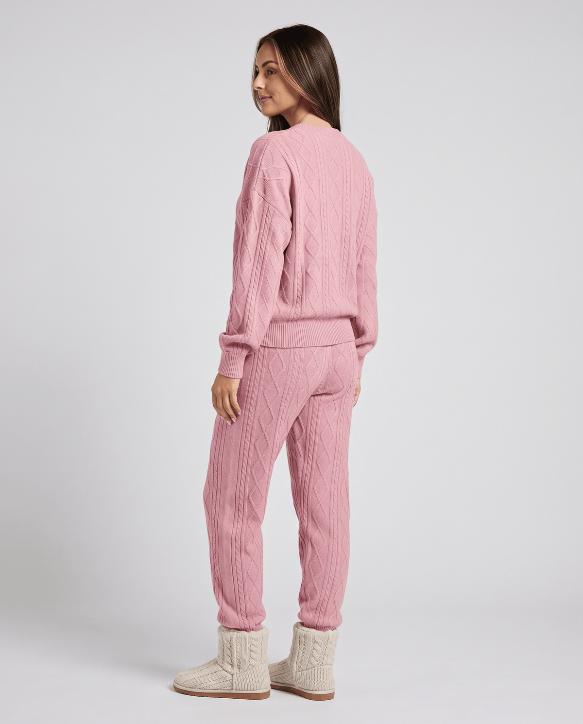 Back view of woman in pink cable knit sweater and jogger pants