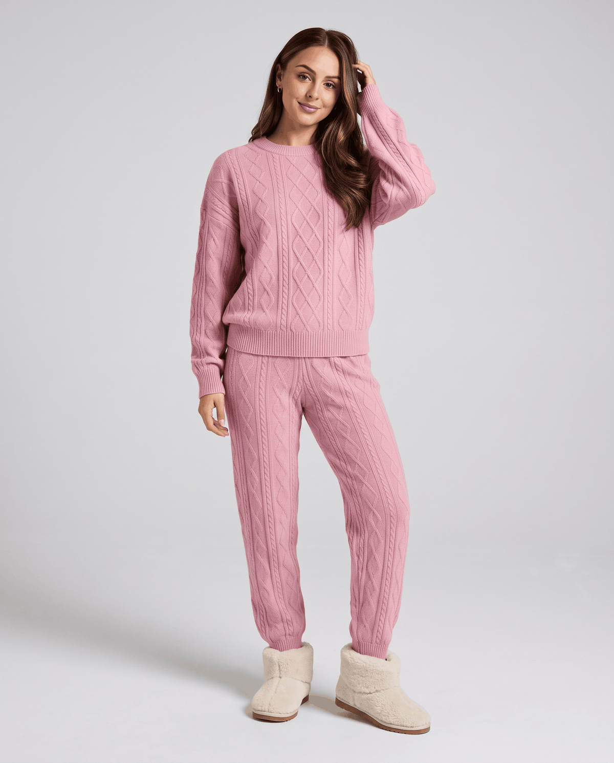Woman wearing a pink cable knit sweater and matching jogger pants