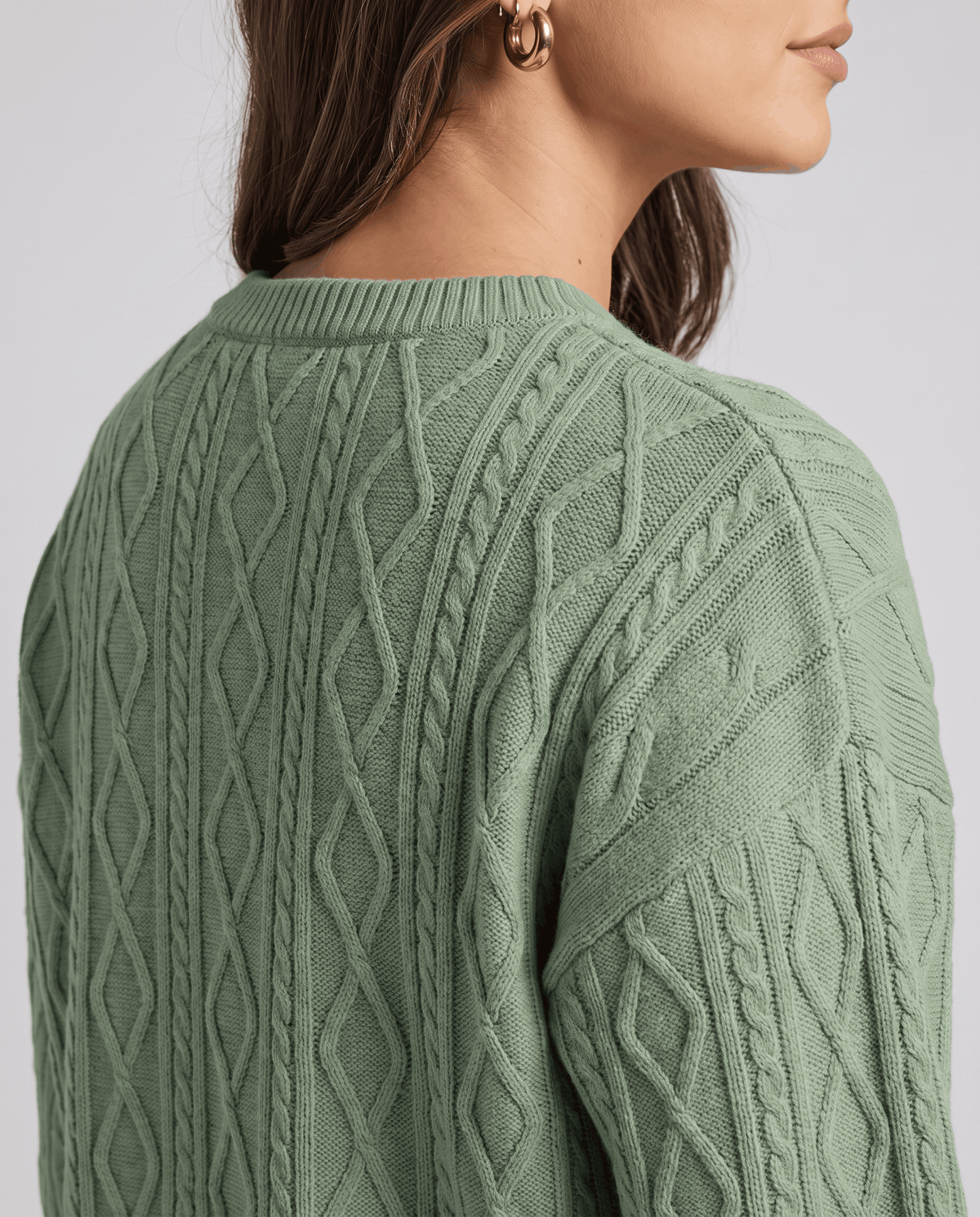 Detail of sage green cable knit pattern on the sweater back