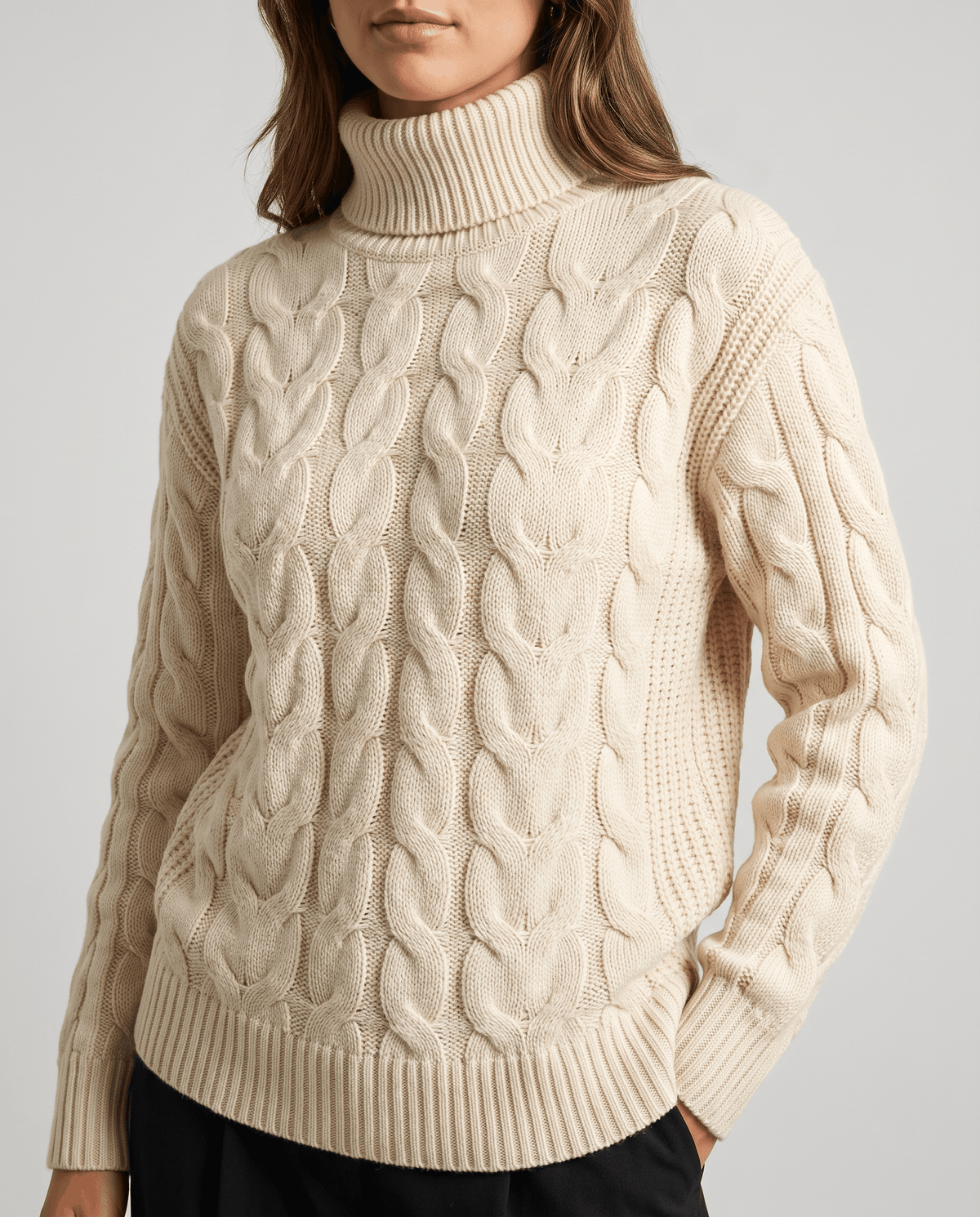 Front close-up of the beige knit with braided cables and ribbed cuffs