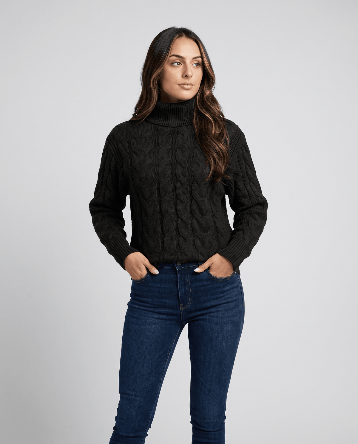 Black cable turtleneck sweater with dark jeans, hands in pockets, front view