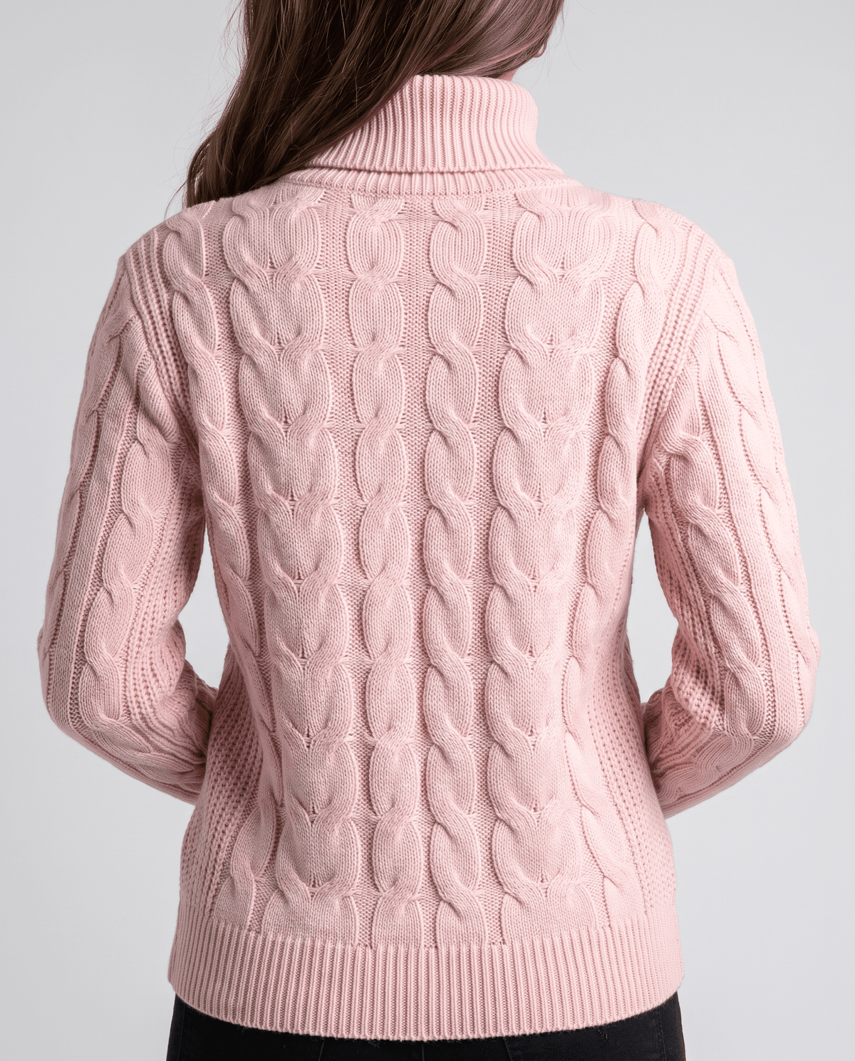 Back view of the pink knit sweater with full-length cable panels and ribbed hem
