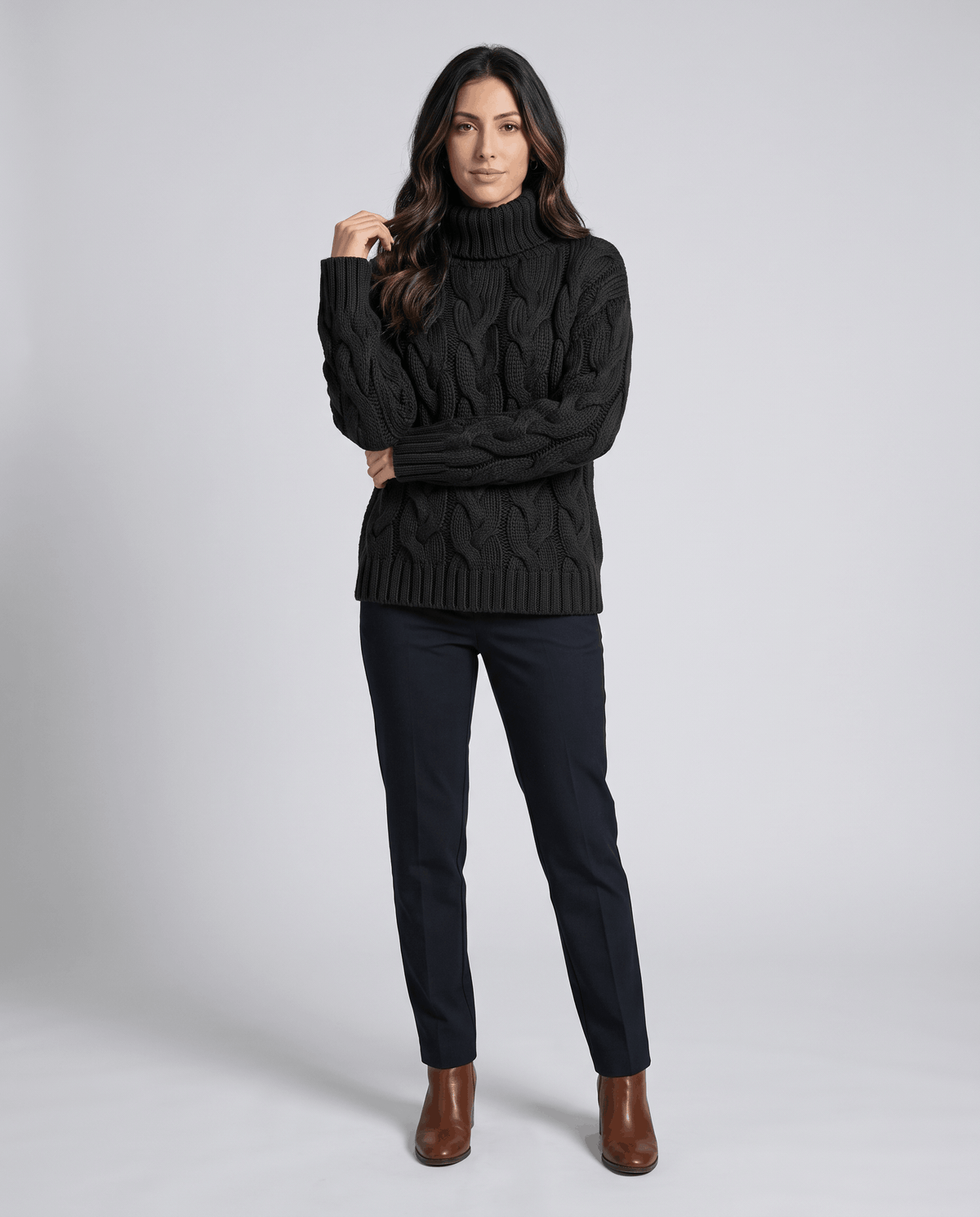 Full-length view of black turtleneck sweater with black pants and ankle boots