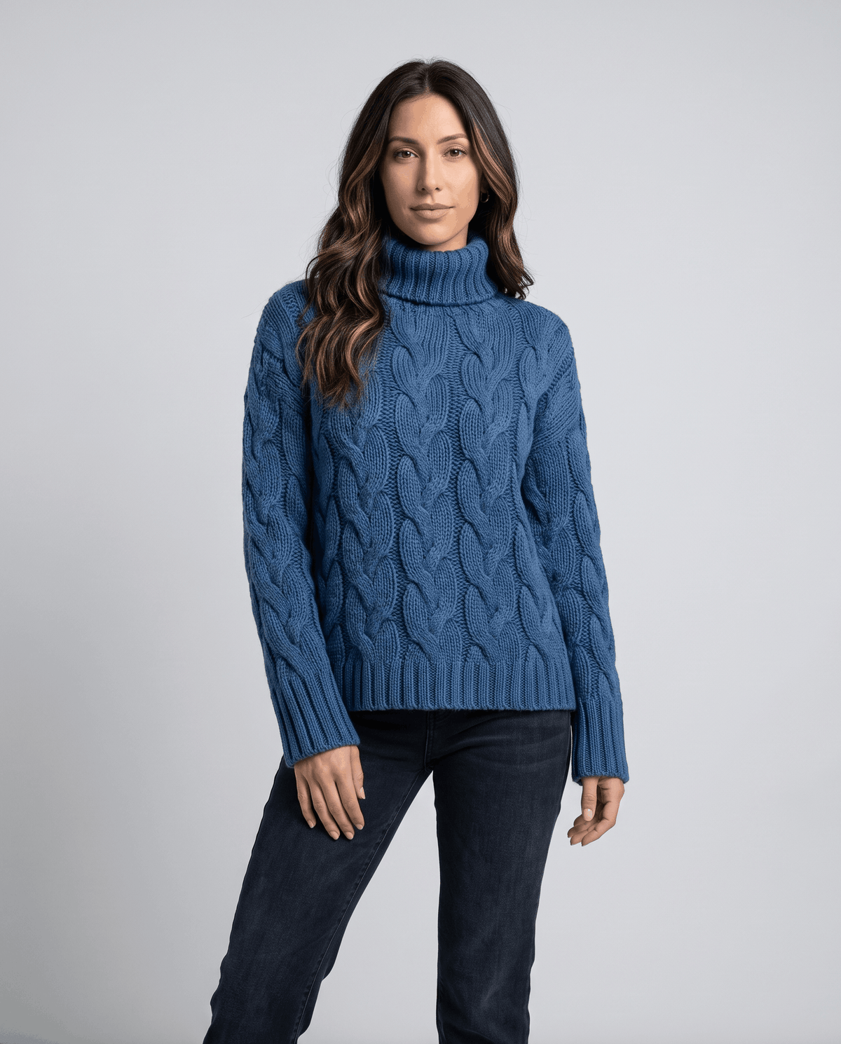 Front view of blue turtleneck sweater worn with dark wash jeans