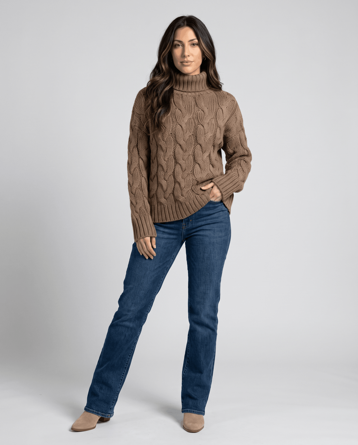Full-length view of brown turtleneck sweater styled with bootcut jeans
