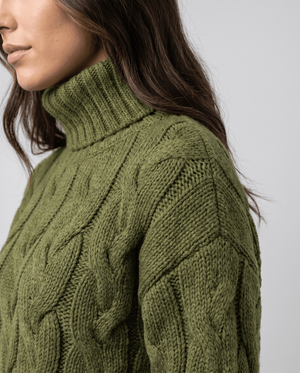 Side detail of olive green ribbed turtleneck and cable knit shoulder