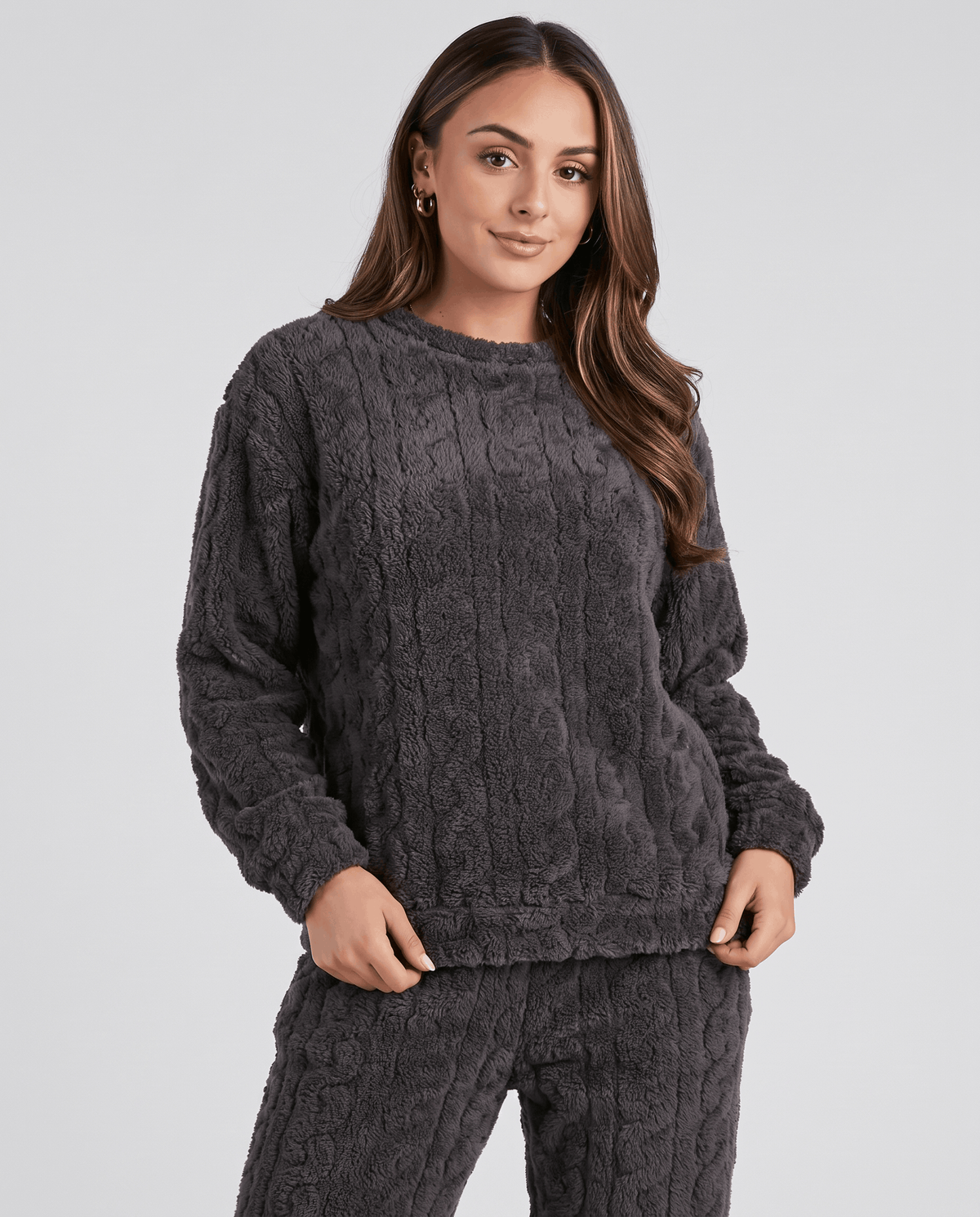 Close-up of woman in a charcoal jacquard crew neck top with long sleeves