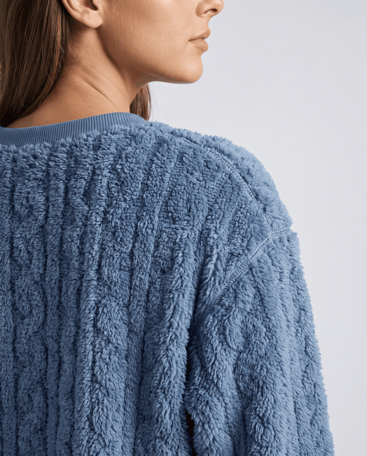 Close-up of denim blue jacquard texture on the shoulder of a plush top