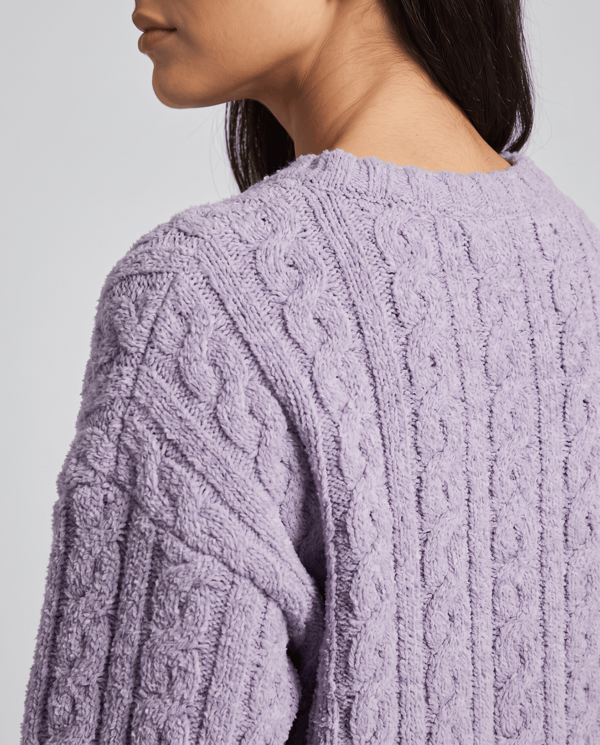 Close-up of lavender jacquard texture on the shoulder and sleeve of a plush top