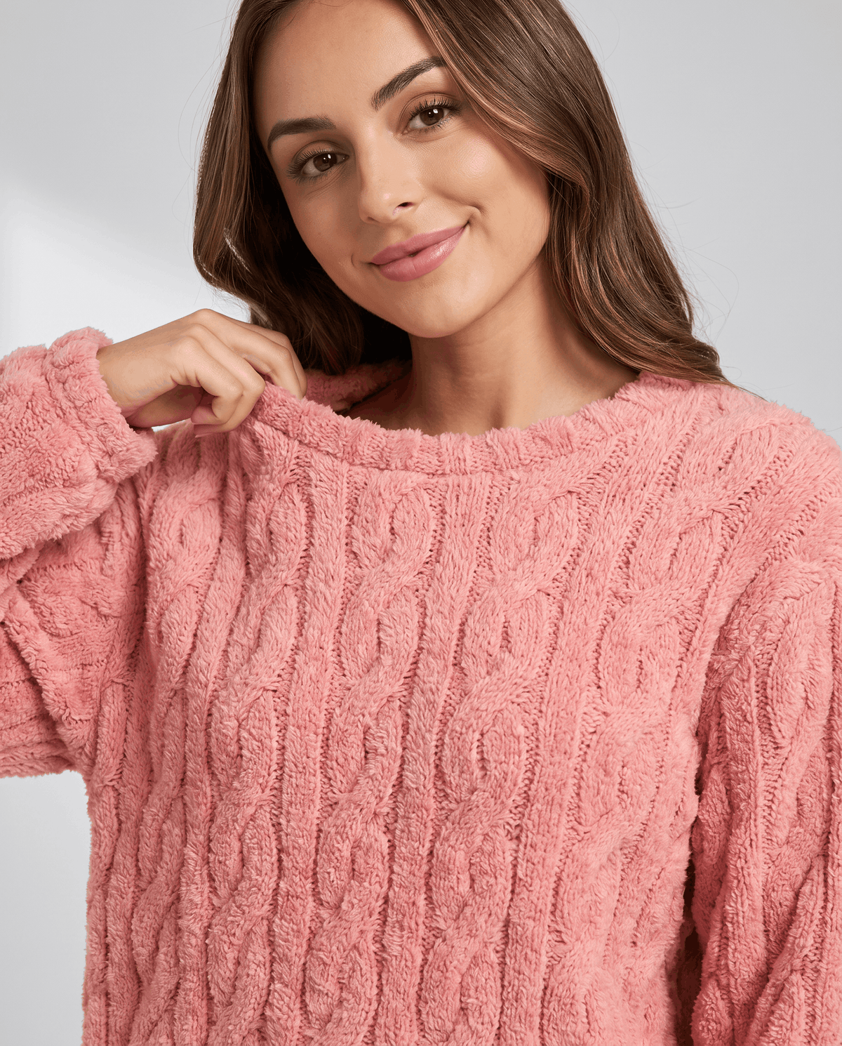 Close-up of pink jacquard crew neck top texture worn by a smiling woman