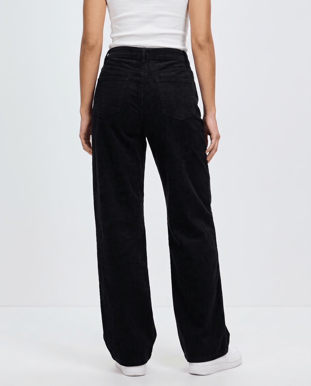 Back view of black wide-leg pants showing the patch pockets and full-length hem