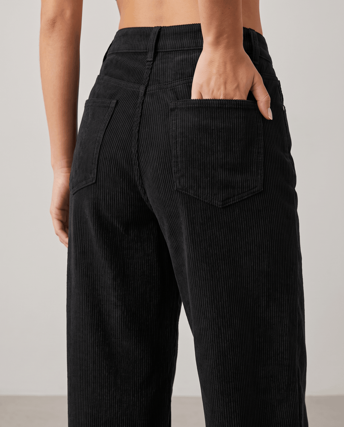 Close-up of a black back patch pocket with a hand resting inside