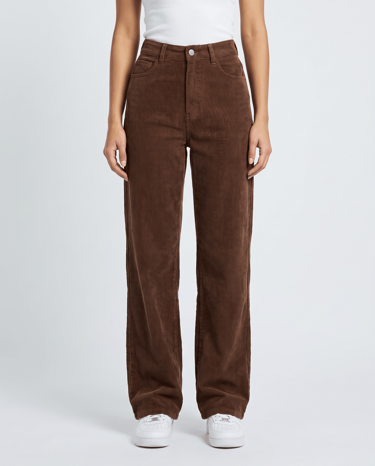 Front view of chocolate brown high-rise ribbed pants with a wide leg and sneakers