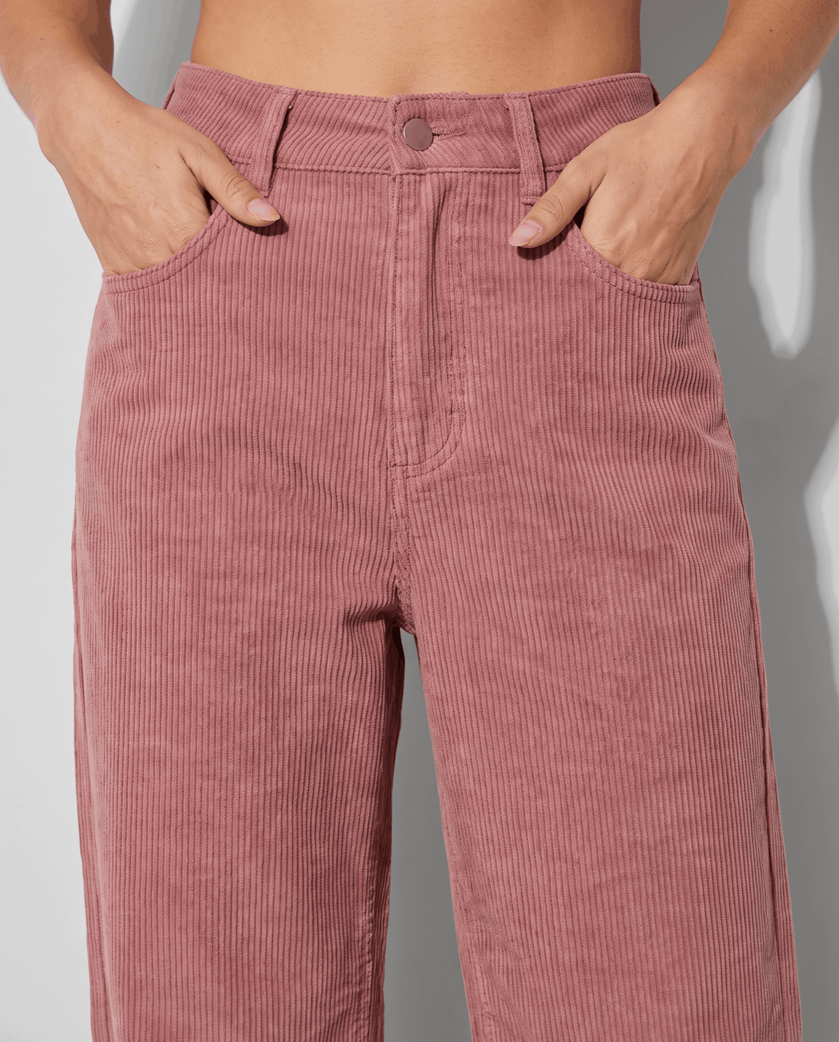 Close-up of the button front, belt loops and front pockets with hands tucked in