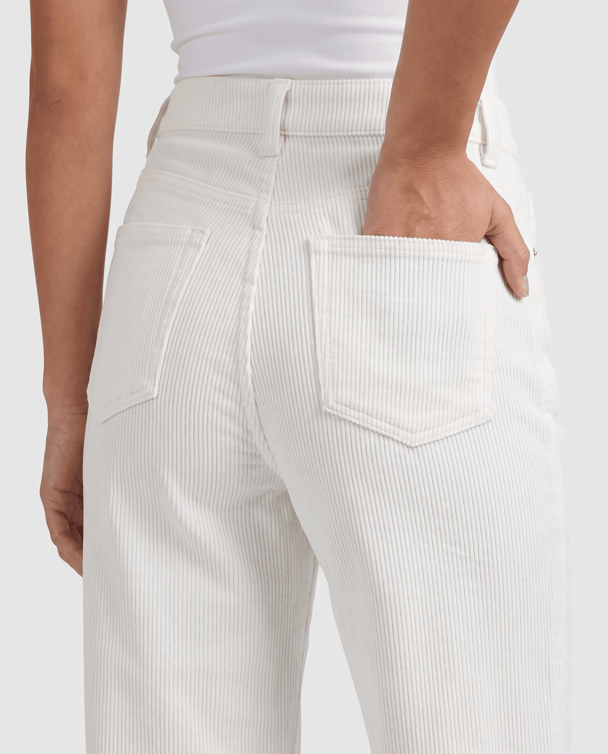 Close-up of a stitched back pocket on cream ribbed corduroy
