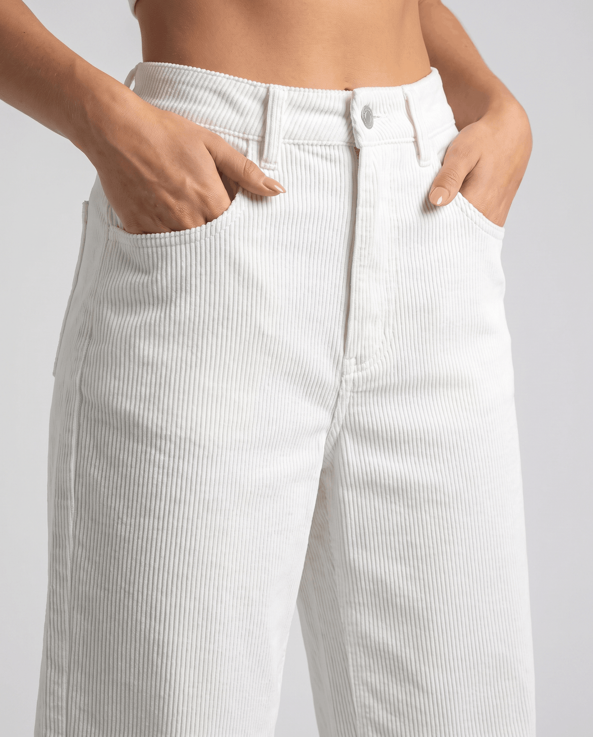 Close-up of the cream button front and belt loops with hands in the front pockets