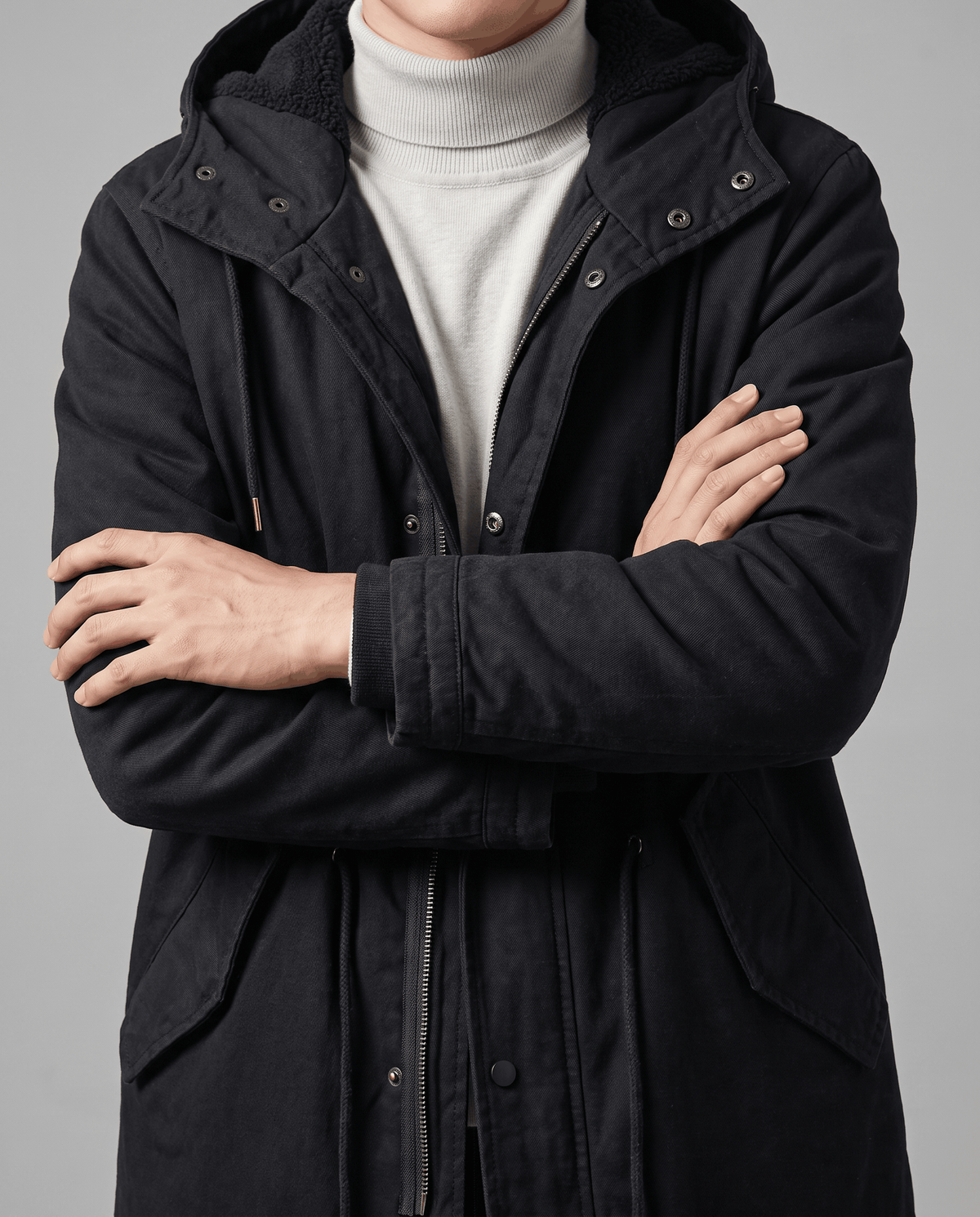 Men's black cotton hooded parka, front close-up with arms crossed