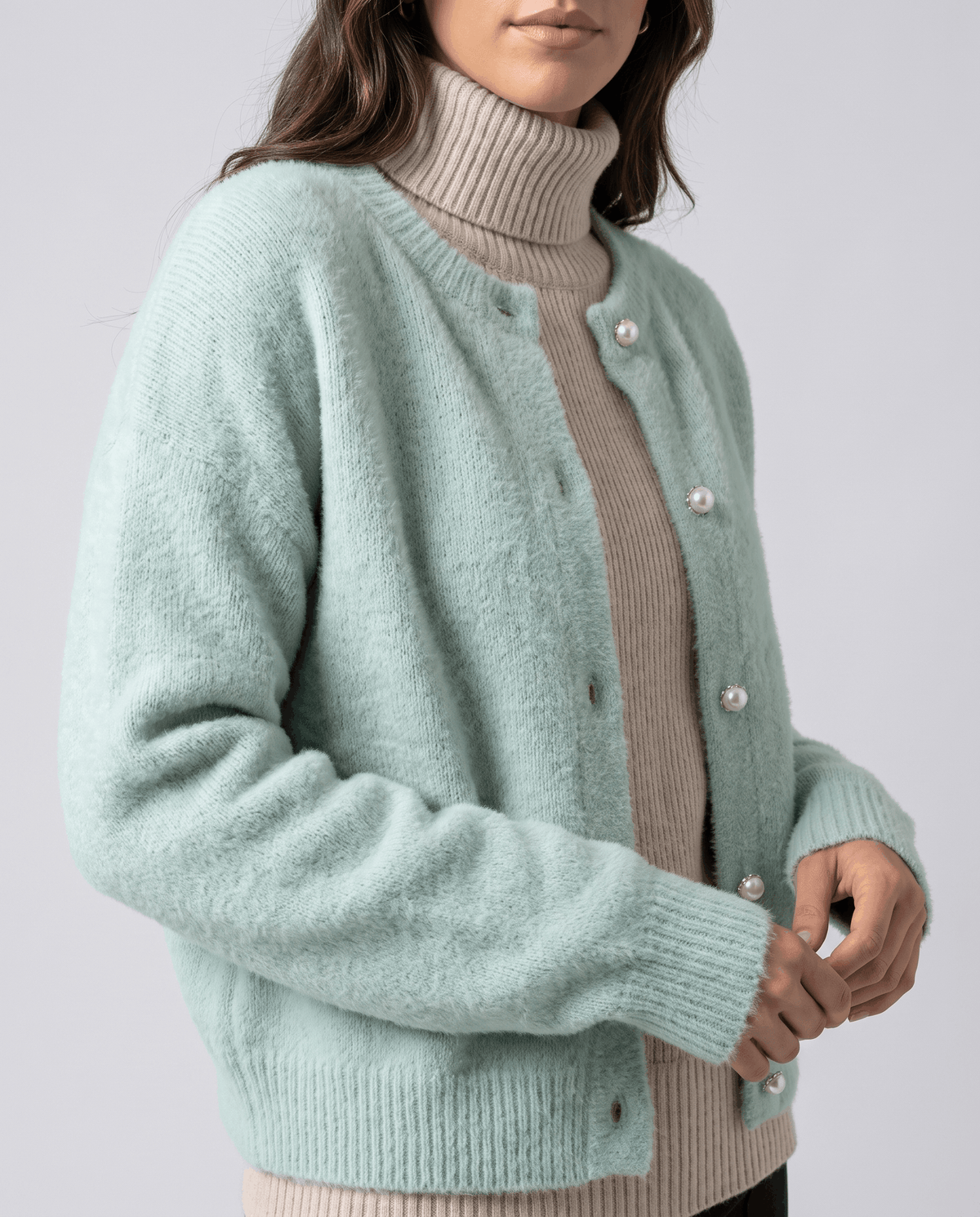 Three-quarter view of the green cardigan over a taupe turtleneck