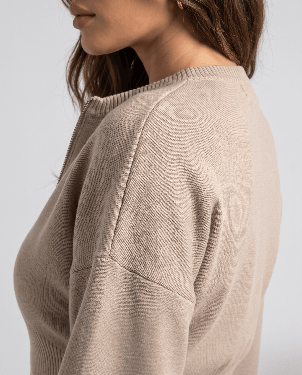 Close-up of the shoulder and sleeve on the beige knit top