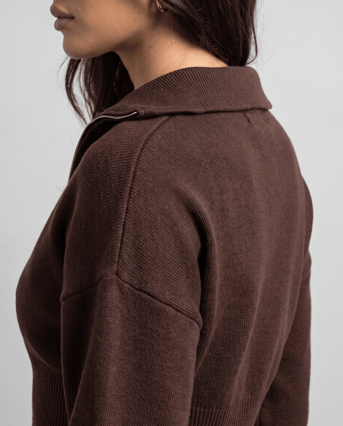Side close-up of the collar and knit texture on the dark brown top