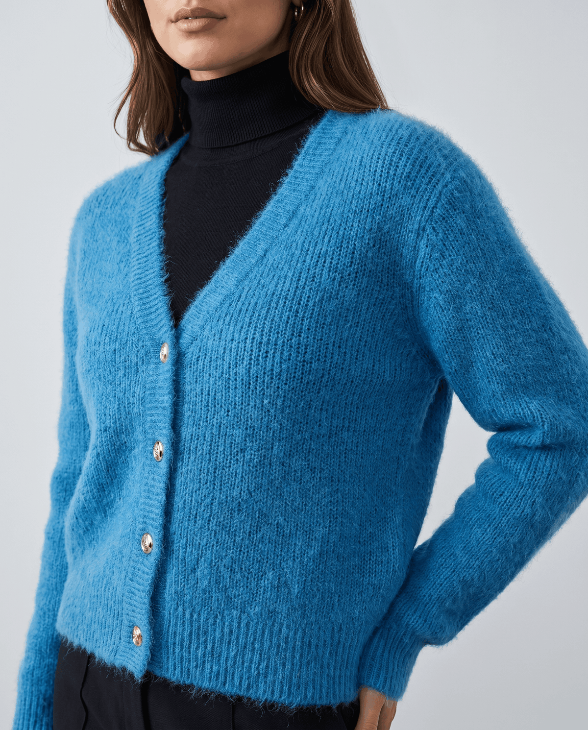 Close-up of the blue cardigan button front worn over a black turtleneck