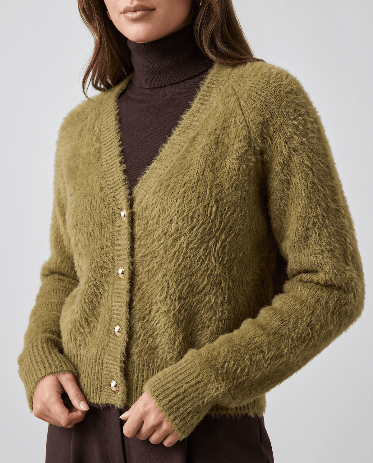 Close-up of the olive green cardigan over a brown turtleneck and dark skirt