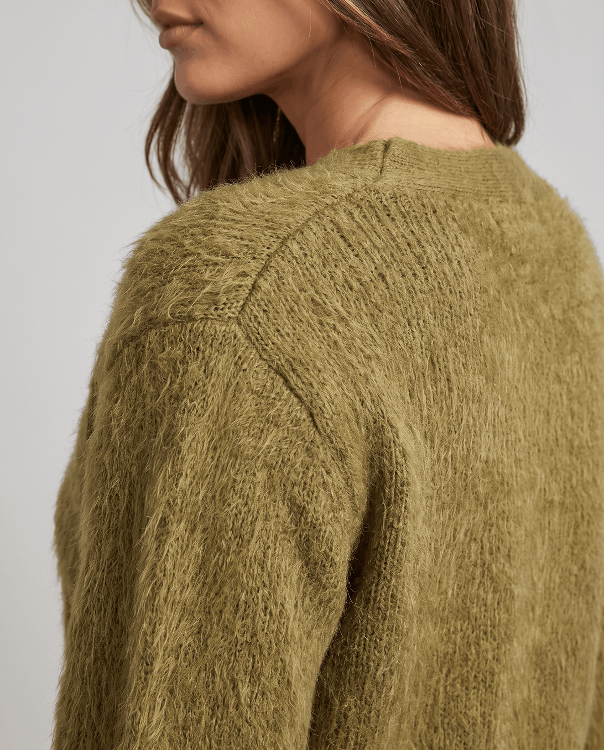 Detail of the olive green fuzzy knit across the shoulder seam