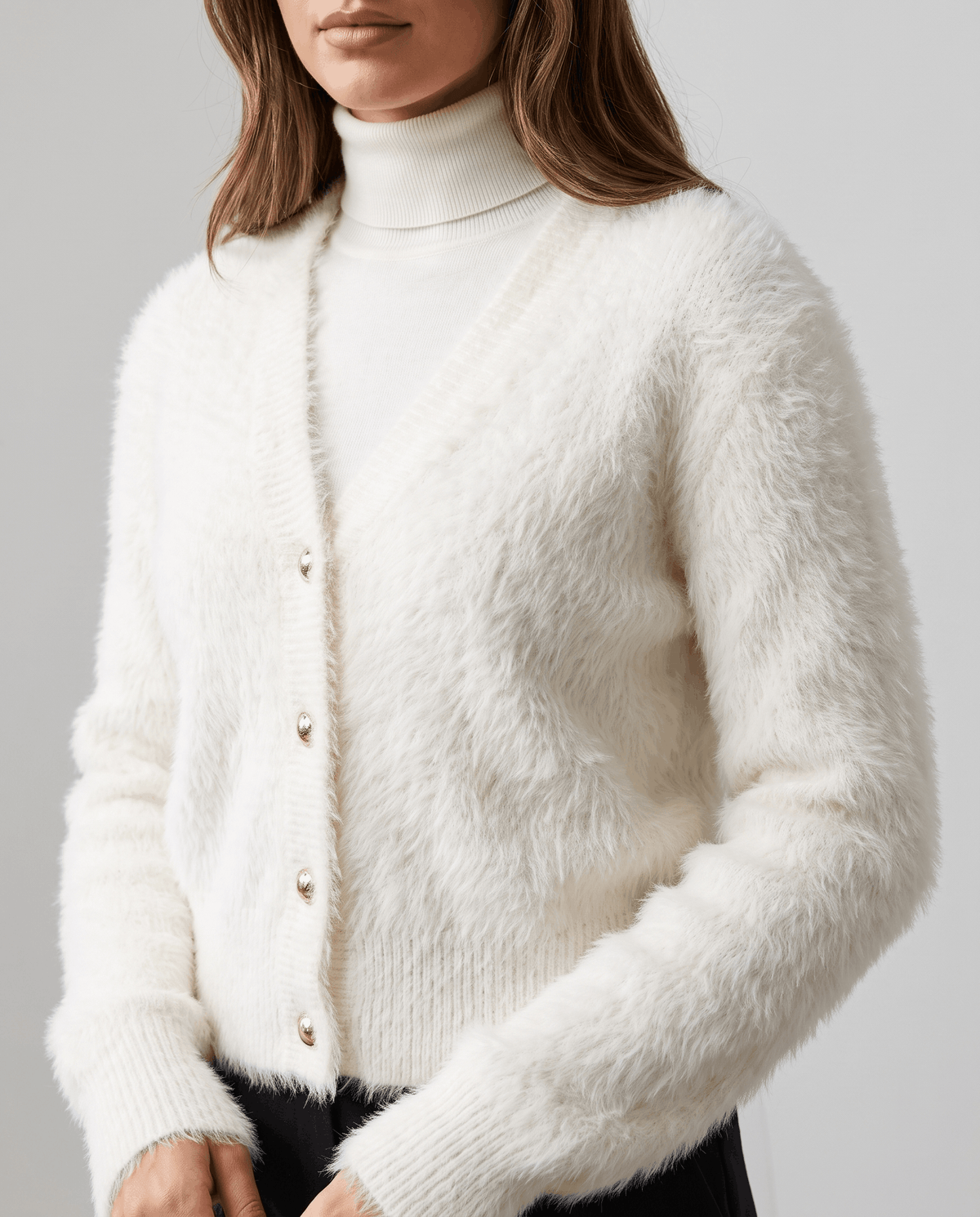 Close-up of the white cardigan button front worn over a white turtleneck