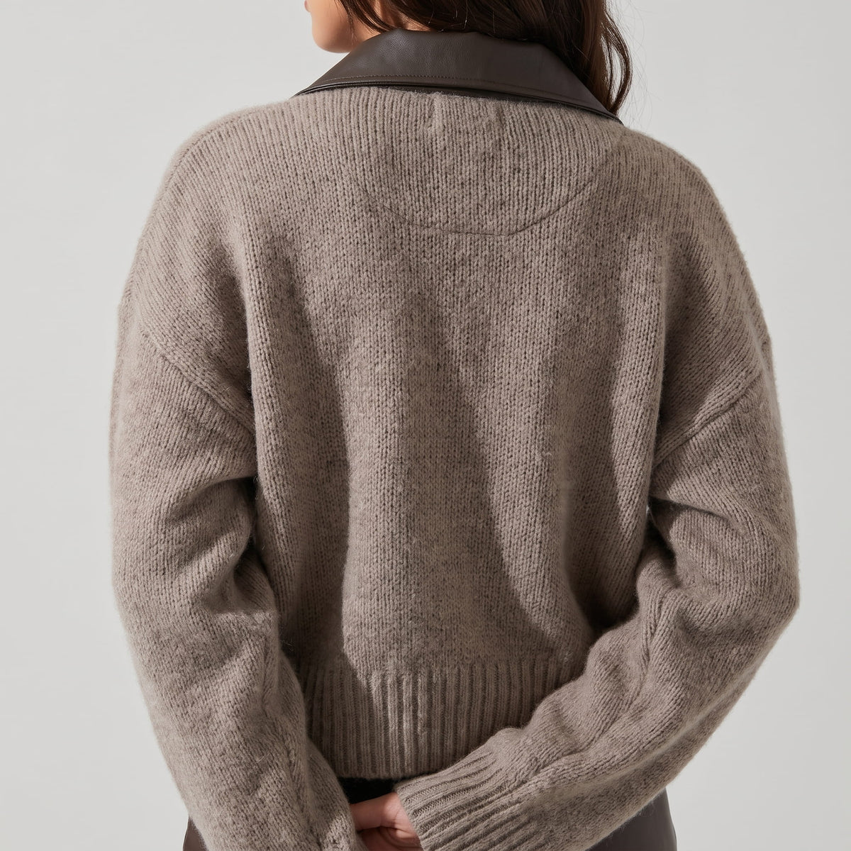 Back view of the heathered knit showing the ribbed hem and dropped shoulders