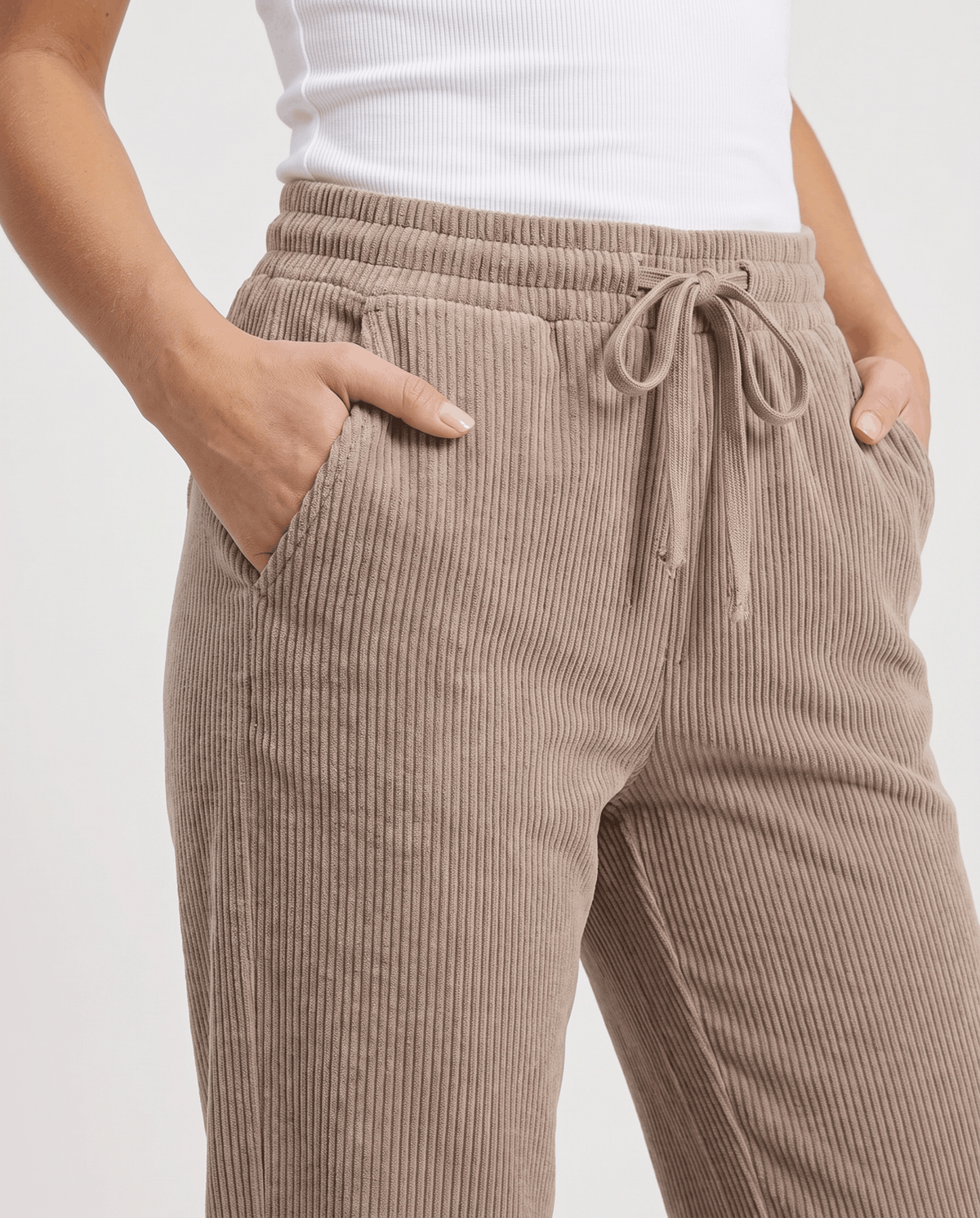 Close-up of the taupe drawstring waist and slanted side pockets on ribbed fabric