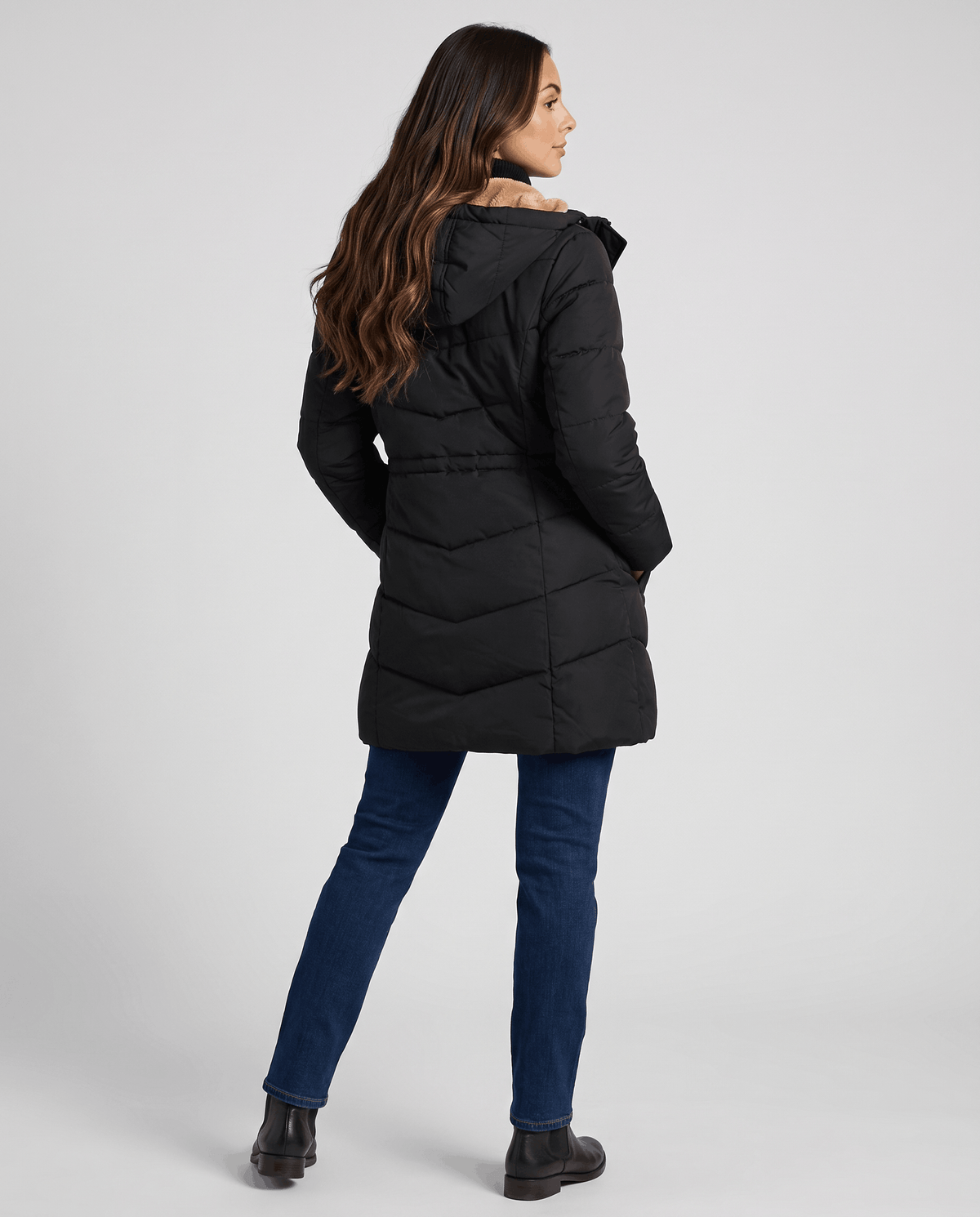 Back view of black parka with hood down over dark jeans