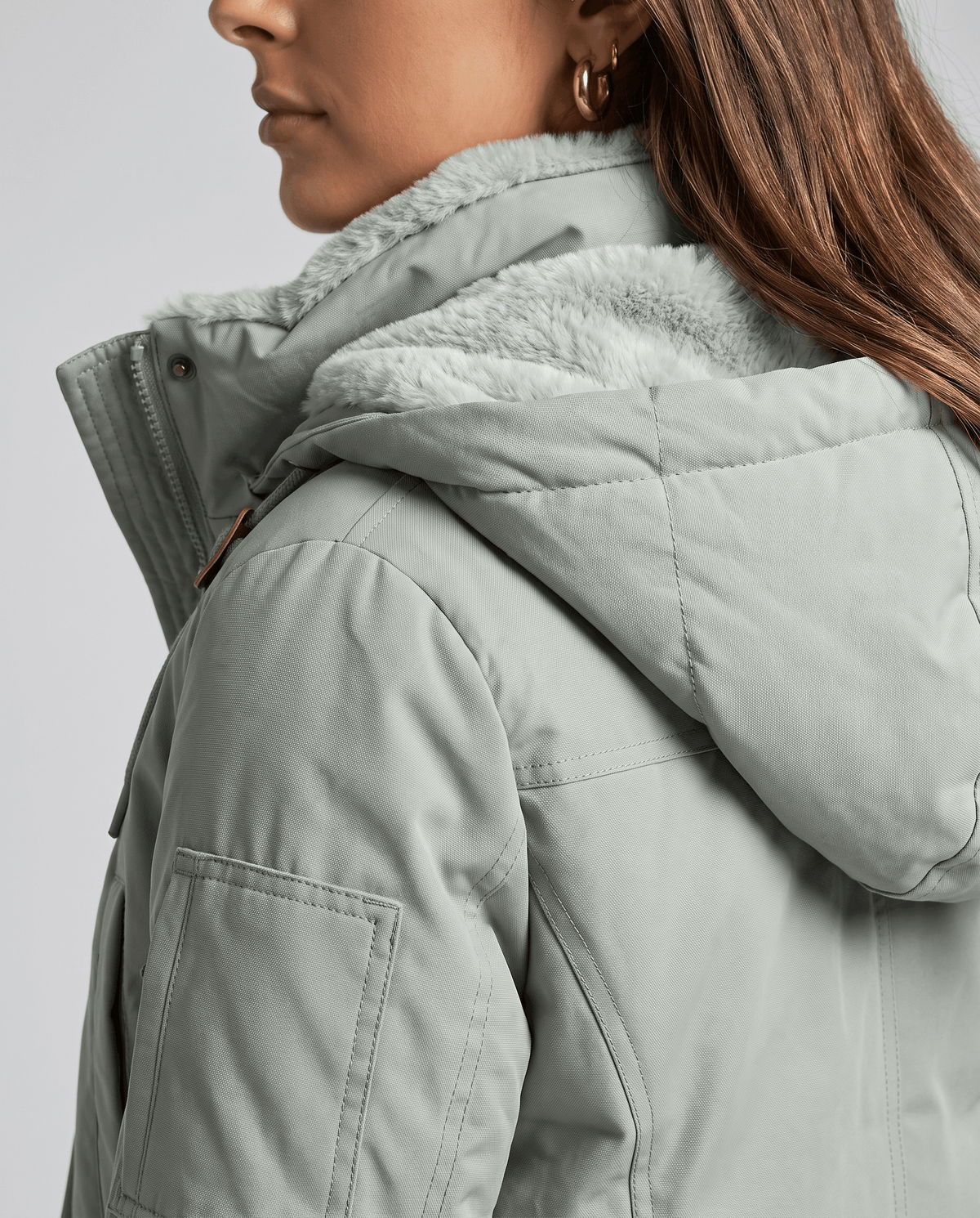 Side close-up of the gray fleece hood lining on a sage green coat