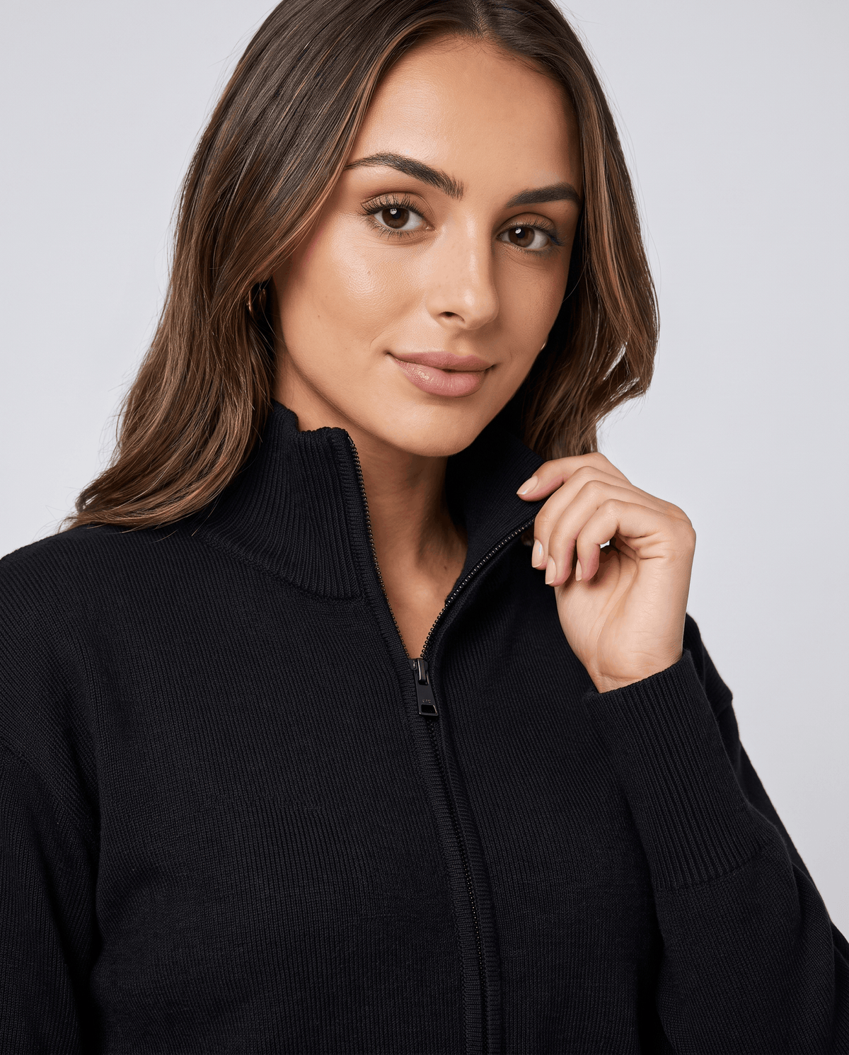 Close-up of the black knit jacket's collar and zip