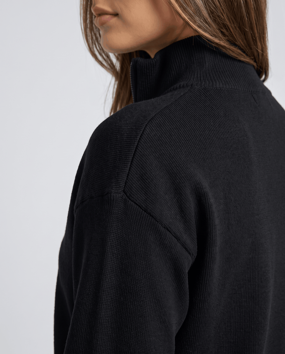 Close-up of the shoulder and collar on the black knit zip jacket