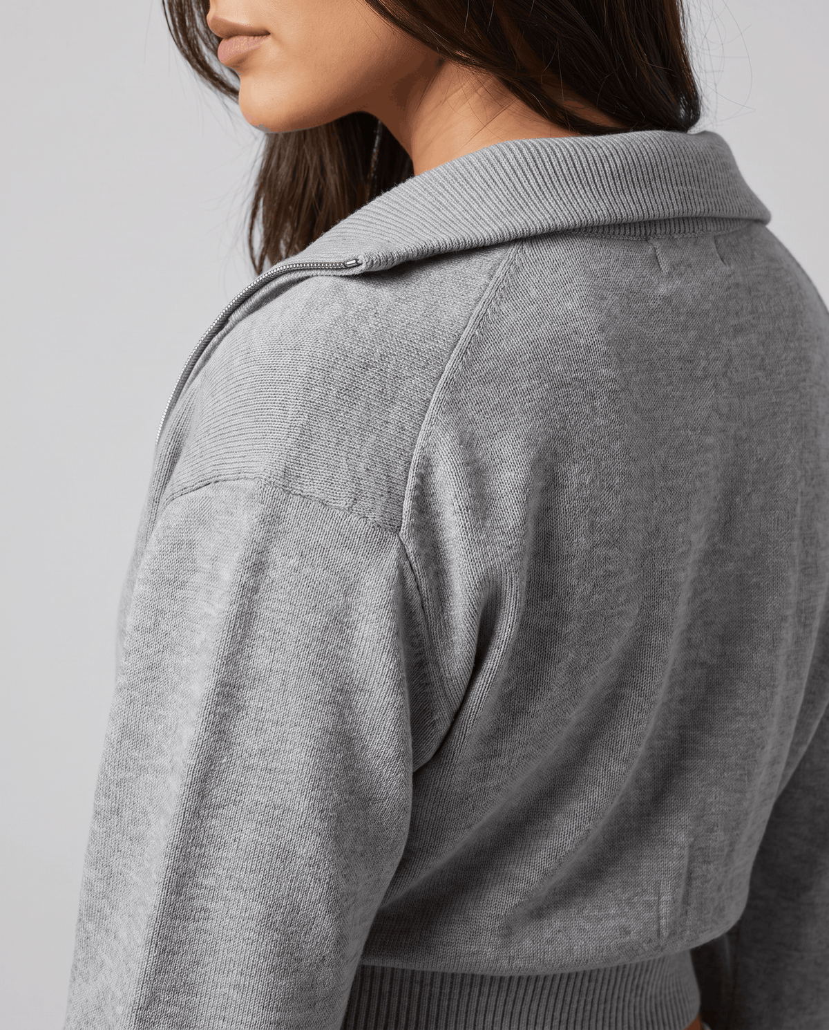 Close-up of the folded collar and zip on the gray knit jacket