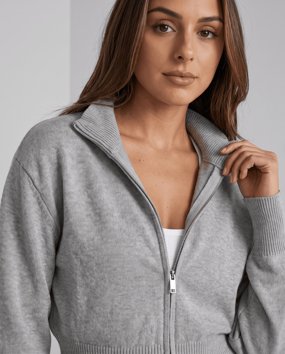 Close-up of the zip, collar and ribbed hem on the gray knit jacket