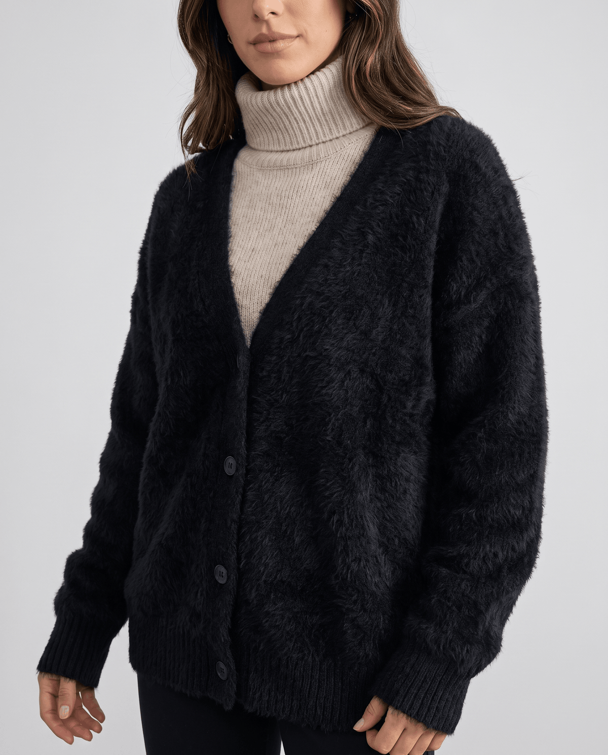Close-up of the black cardigan V-neck over a taupe turtleneck