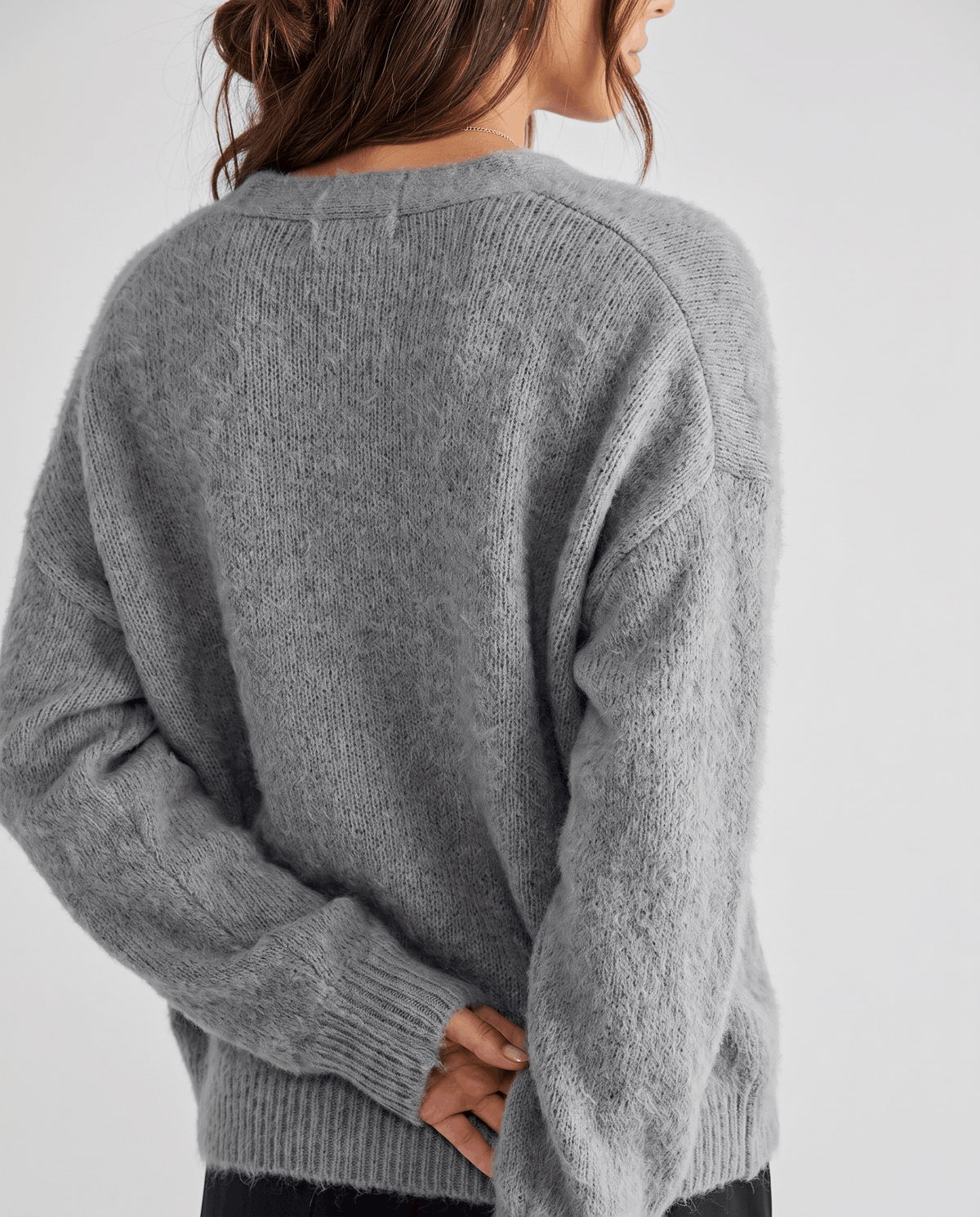 Back view of the light gray cardigan showing its oversized shape